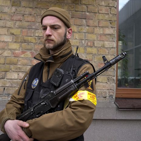 Ein Mitglied der ukrainischen Bürgerwehr patrouilliert auf einer Straße in Kiew