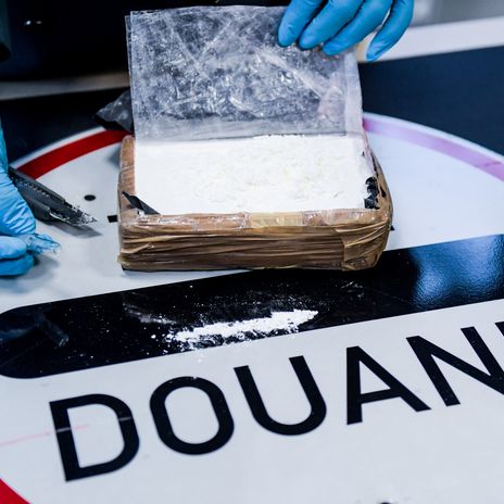 A German customs officer inspects a package of cocaine from South America