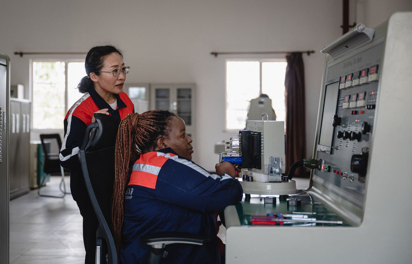 Chinese instructor Chen Ling (L) instructs apprentice Judith Wanzila Peter on operating electrical devices in Nairobi, Kenya, May 23, 2023.