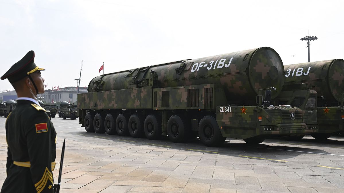 Ein Soldat steht vor einer großen Rakete.