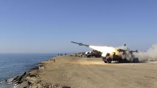 Eine Rakete wird auf einer Anhöhe über dem Meer gezündet.