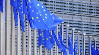Eine Reihe von EU-Flaggen vor einem Bürogebäude
