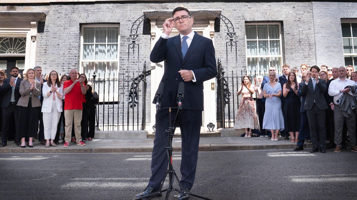 Der neue britische Premierminister Andy Burnham hält vor der 10 Downing Street in London seine erste Ansprache. Der Premierminister steht vor einer Hauswand und klatschenden Menschen.