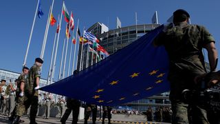 Eurocorps soldiers hold the European flag in front of the EU Parliament in Strasbourg, France.