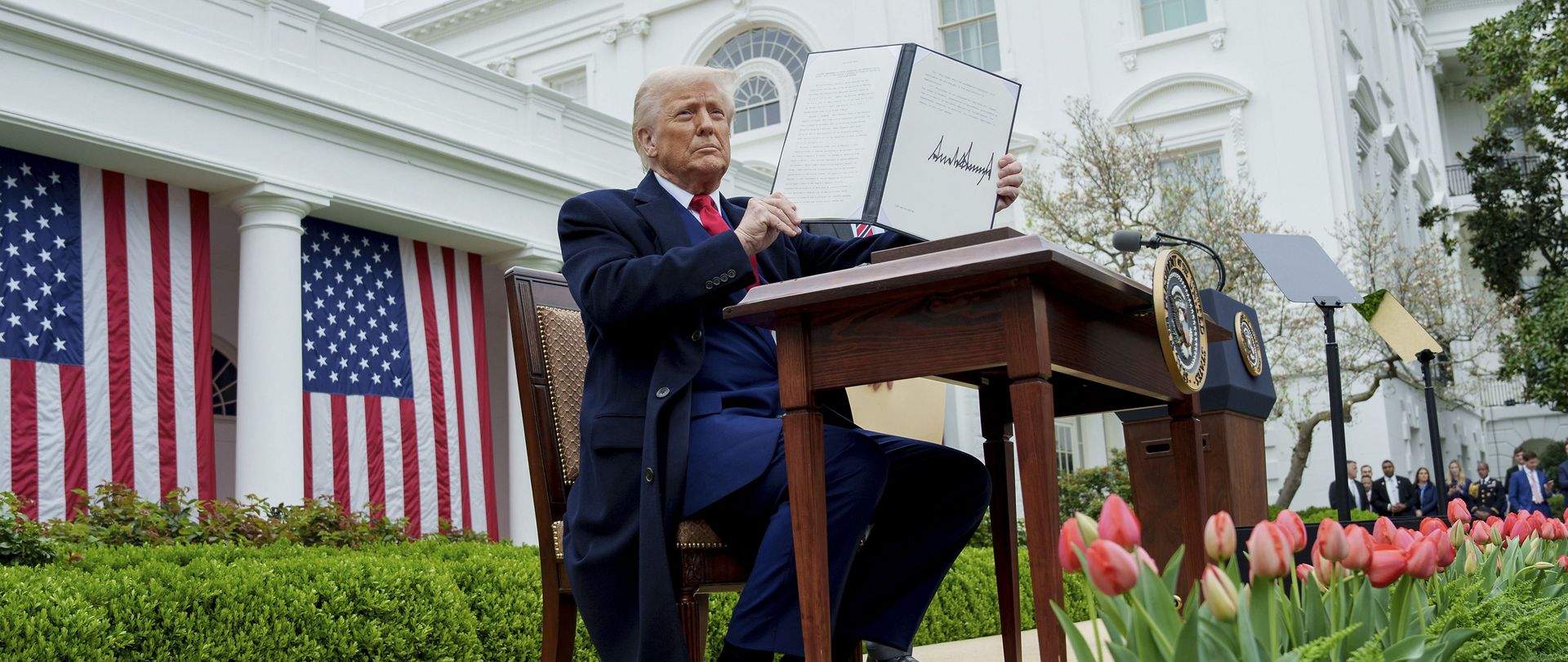 Donald Trump holds up a signed document
