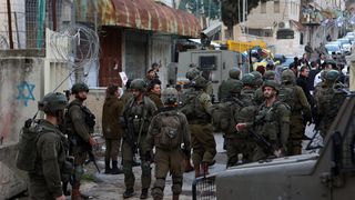 Israeli security forces guard Israeli settlers on their tour of the West Bank city of Hebron.