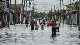 Einwohner der kubanischen Stadt Batabanó waten nach dem Hurrikan Helene im September 2024 durch eine Straße