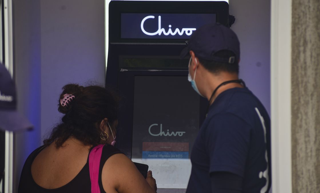 Bitcoin-Einführung in El Salvador: Ein Regierungsmitarbeiter hilft einer Kundin, einen Chivo-Geldautomaten zu nutzen