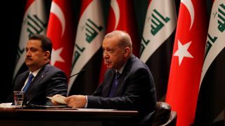 Turkish President Recep Tayyip Erdogan and Iraqi Prime Minister Mohammed Shia al-Sudani sit next to each other