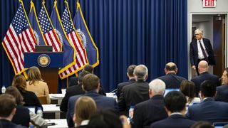 US-Notenbankchef Jerome Powell auf einer Pressekonferenz, neben ihm US-Flaggen