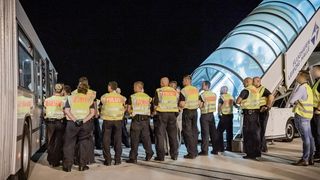 Polizeibeamte begleiten einen Afghanen auf dem Flughafen Leipzig-Halle in ein Charterflugzeug