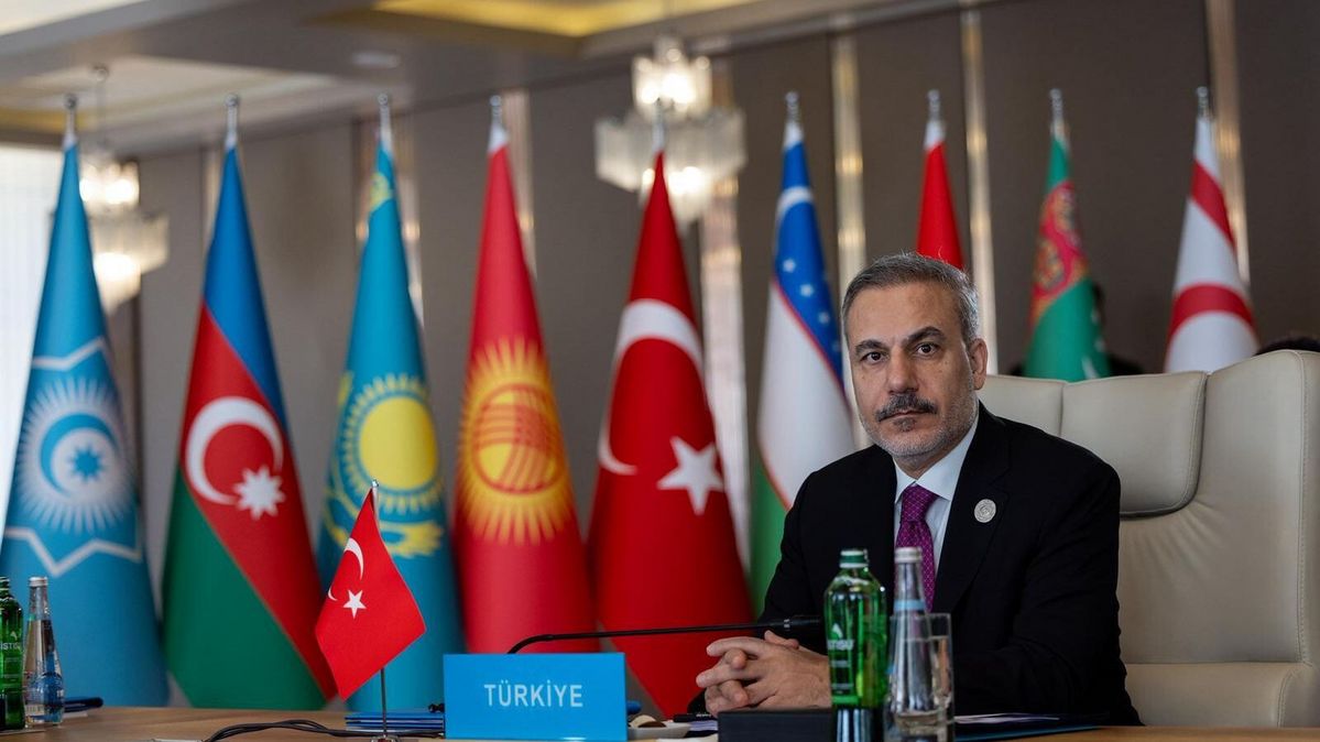 Man in front of flags