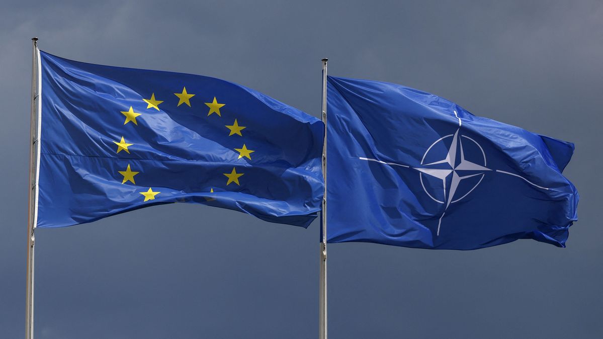Eine EU- und eine NATO-Flagge wehen im Wind