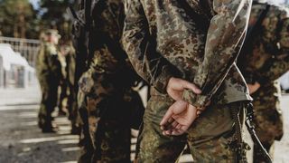 Mehrere Soldaten stehen nebeneinander in einer Reihe.