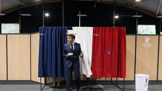 French President Emmanuel Macron leaves the voting booth in Le Touquet.