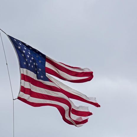 Symbolbild: Eine zerfetzte US-Flagge flattert im Wind, Detroit, Michigan, USA.