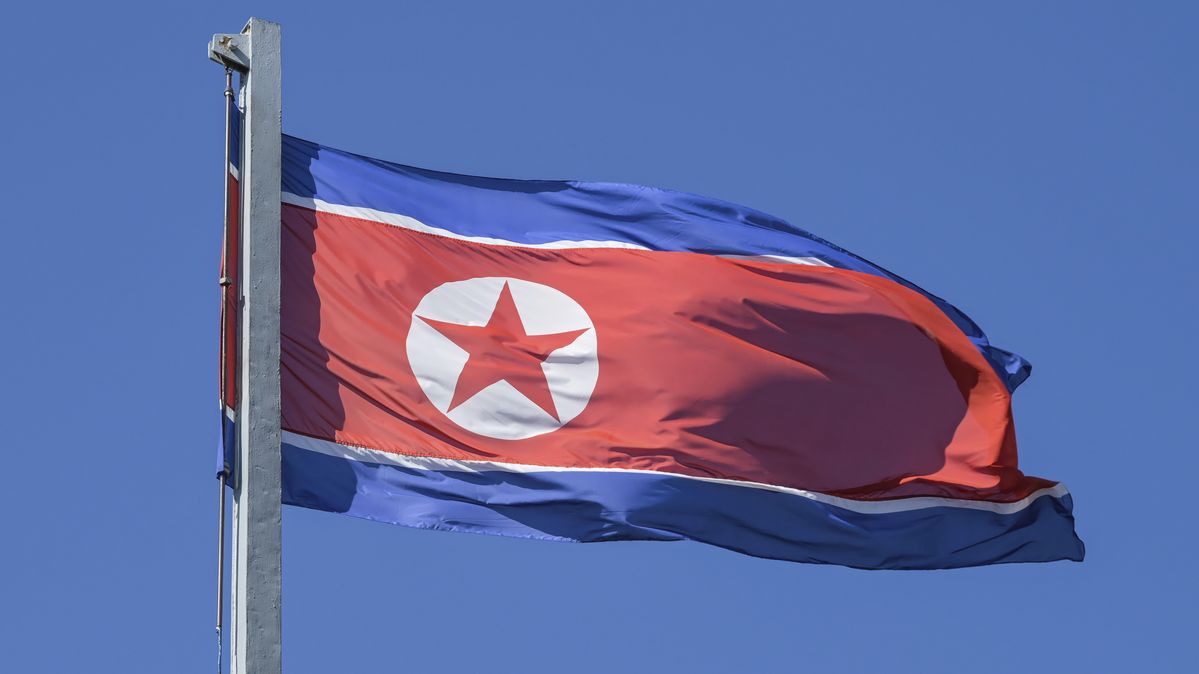 Die nordkoreanische Fahne an einem Mast vor blauem Himmel
