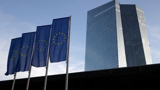Vier EU-Flaggen neben den beiden Türmen der Europäischen Zentralbank