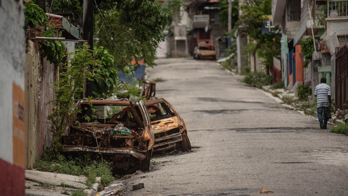 Port-au-Prince, Haiti: Spuren der Gewalt - von Banden zerstörte Autos prägen die Nachbarschaften. Zwei ausgebrannte Autos stehen an einer Straße.